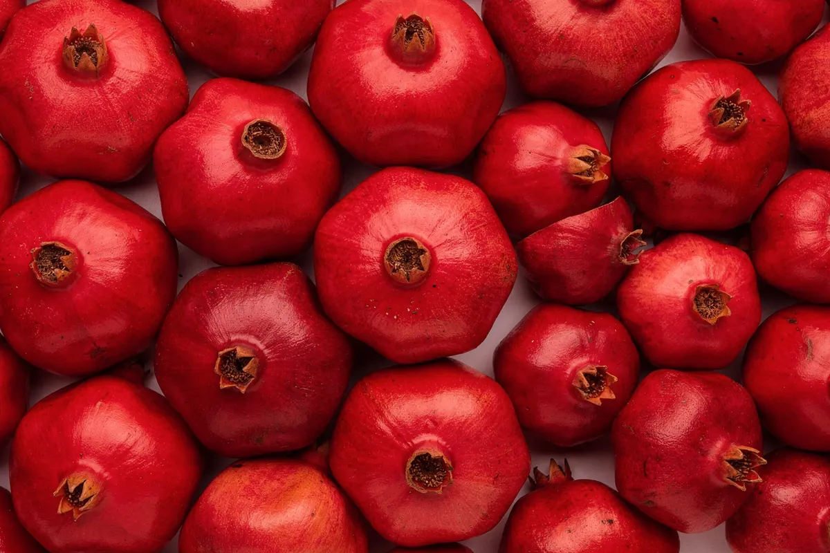 Fresh pomegranates, whole and halved